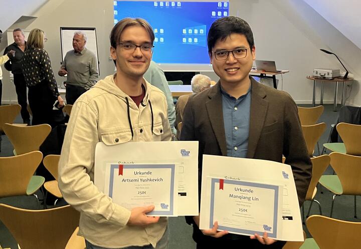 Artsemi Yushkevic and Manqiang Lin with their prizes.