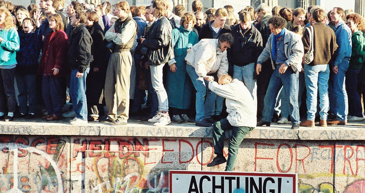 Menschen auf der Berliner Mauer nahe dem Brandenburger Tor am 9. November 1989