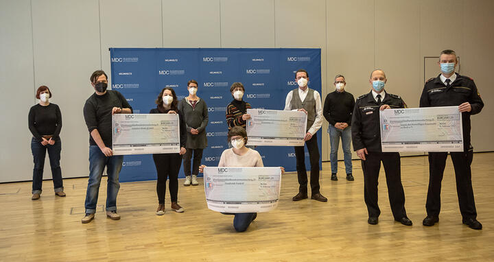 Group picture of the participants. Recipients hold checks in the air.