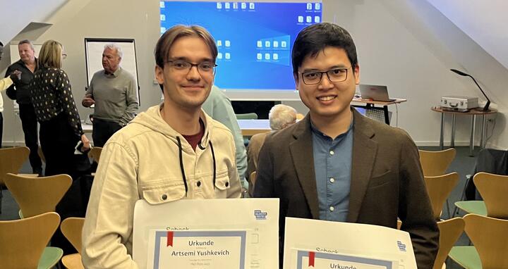 Artsemi Yushkevic and Manqiang Lin with their prizes.