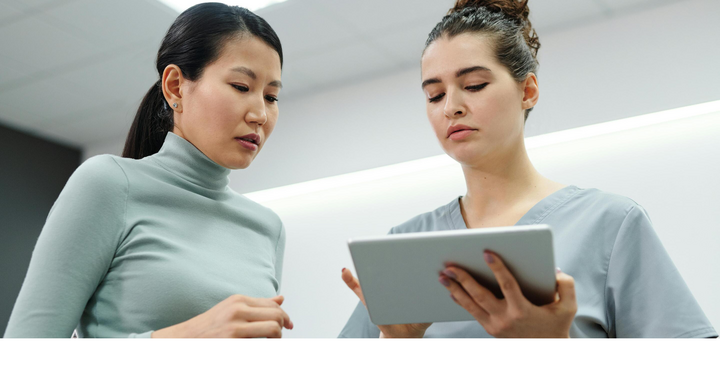 Two people are looking at a tablet