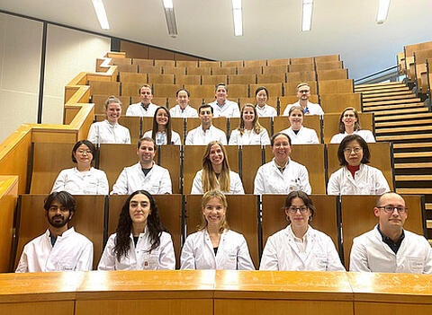 People wearing lab coats sitting in an auditorium