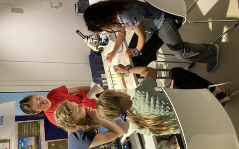 Children at a stand with scientific equipment