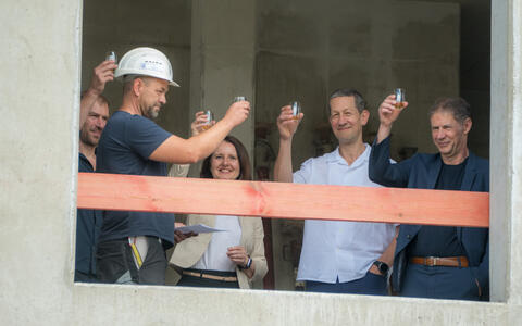 People raise their glasses at the topping-out ceremony