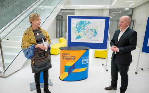 a woman and a man talk to each other in a foyer