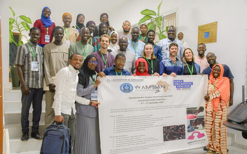 Gruppenfoto der Teilnehmer des WAMBIAN Bio-Imaging-Workshops, die ein Banner mit den Veranstaltungsdaten halten.