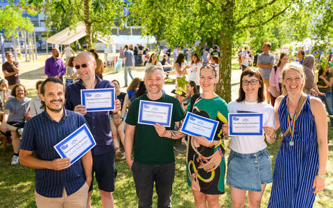 Group holding certificates for the Marvelous Mentor Award at a summer gathering.