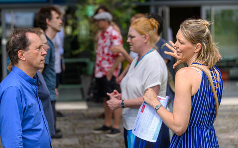 Attendees in conversation during an outdoor networking session.