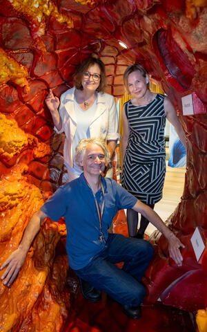 Three people standing inside a walk-in artery.