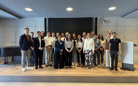Group photo of attendees smiling on stage at a conference event