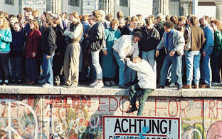 Menschen auf der Berliner Mauer nahe dem Brandenburger Tor am 9. November 1989