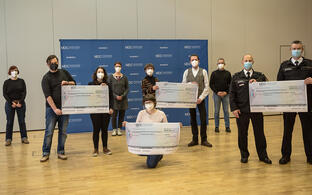 Group picture of the participants. Recipients hold checks in the air.