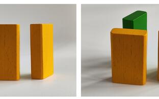 on the left side there are two yellow wooden blocks, on the right side a third block in green color appears due to a different perspective