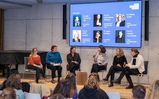 View from the audience onto a stage where a panel discussion is taking place