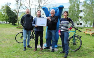 Four people with bicycles and a seal