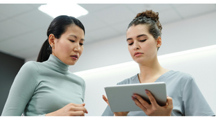 Two people are looking at a tablet