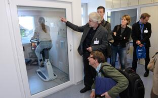 Michael Boschmann, MD, of the ECRC explains the metabolic chamber to the new Helmholtz President Otmar Wiestler.