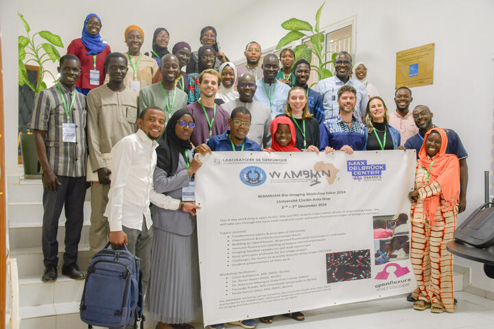 Group photo of participants at the WAMBIAN Bio-Imaging Workshop holding a banner with event details.