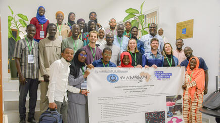 Gruppenfoto der Teilnehmer des WAMBIAN Bio-Imaging-Workshops, die ein Banner mit den Veranstaltungsdaten halten.