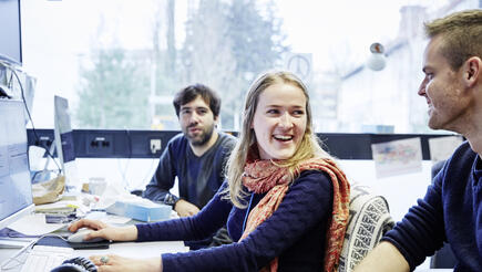 Scientists at a desk laughing