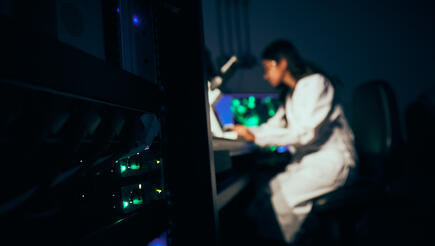 female scientist working at a microscope 