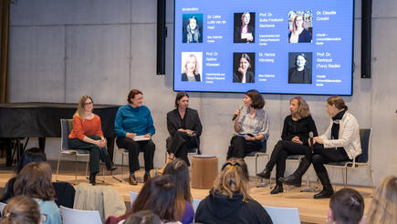 View from the audience onto a stage where a panel discussion is taking place